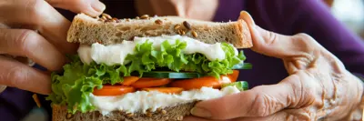 Senior holding sandwich and smiling