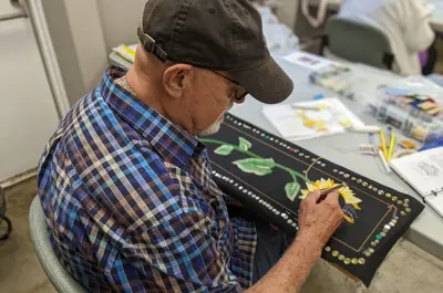Man working on bunka embroidery