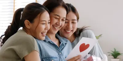 Mother and daughters looking at card
