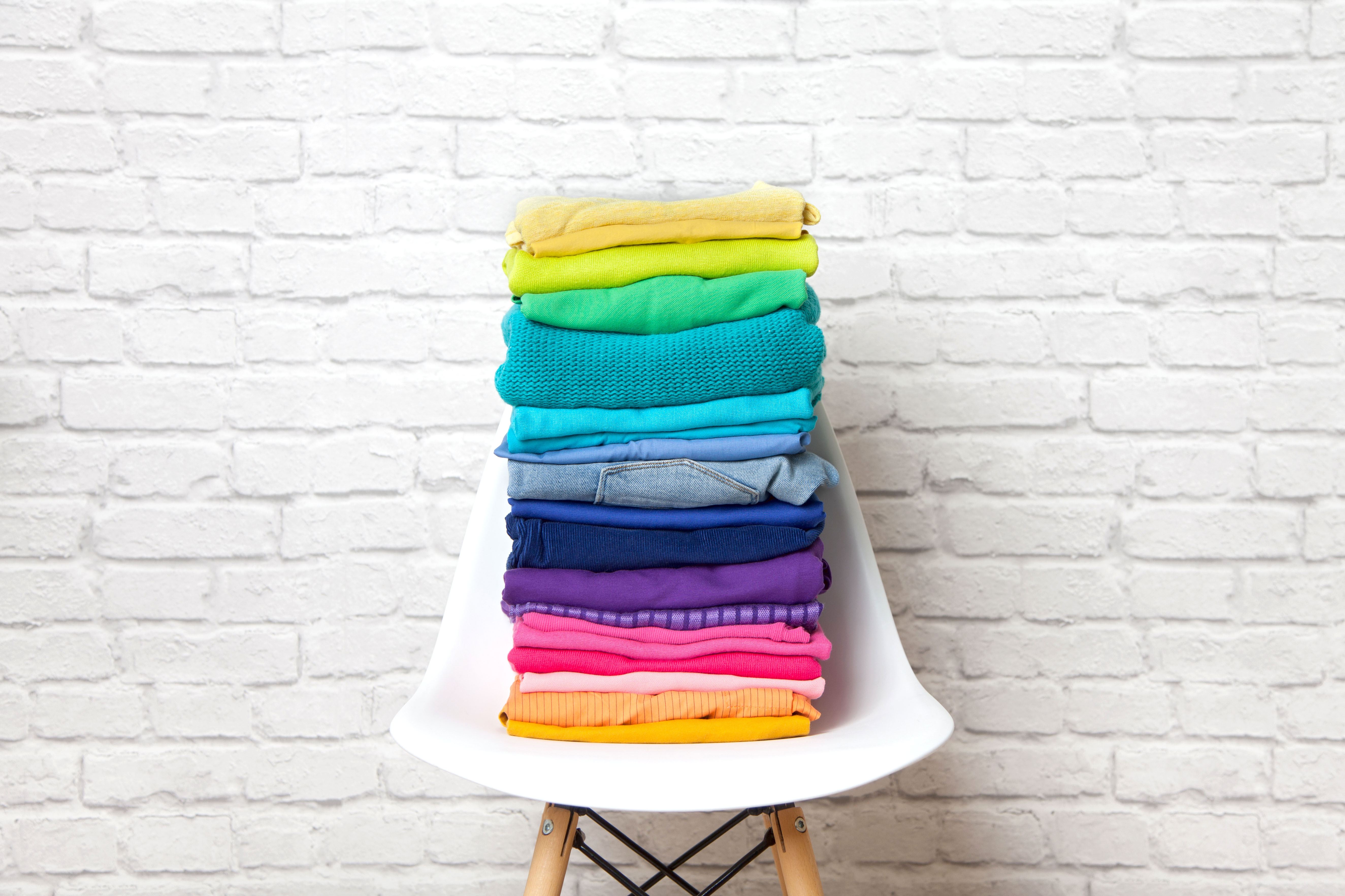Rainbow clothing stacked on chair